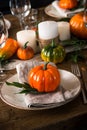 Autumn table setting with plate, pumpkin and candles.