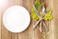 Thanksgiving dinner plate with fork, knife and autumn leaves on rustic wooden table background. Top view, copy space Royalty Free Stock Photo