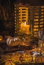 Autumn terrace in night with white pumpkins, lights and dried leaves Royalty Free Stock Photo