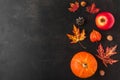 Autumn or thanksgiving composition made of autumn leaves, flowers, pumpkin, apple on black background. Flat lay