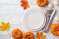 Autumn Thanksgiving table setting for dinner with plate, knife, fork decorated pumpkins and maple leaves. Top view Royalty Free Stock Photo