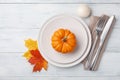 Autumn Thanksgiving table setting for dinner with plate, knife, fork decorated pumpkins and maple leaves. Top view Royalty Free Stock Photo