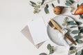 Autumn Thanksgiving table setting. Golden cutlery, plate, berry eucalyptus leaves, branches. Blank greeting card