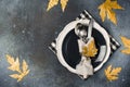 Autumn thansgiving and halloween tableware flat lay with plate and leaves on dark background