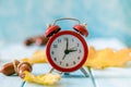 Autumn time change concept - red alarm clock on wood background Royalty Free Stock Photo