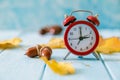 Autumn time change concept - red alarm clock on wood background Royalty Free Stock Photo