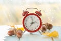 Autumn time change concept - red alarm clock on wood background Royalty Free Stock Photo