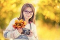 Autumn time. The teenage attractive cute young girl with autumn bouquet and retro camera. Young girl photographer autumn season Royalty Free Stock Photo