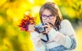Autumn time. The teenage attractive cute young girl with autumn bouquet and retro camera. Young girl photographer autumn season Royalty Free Stock Photo