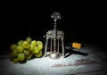 Autumn is the time for winemaking. Composition with a bottle of wine, a bunch of white grapes and a corkscrew on a wooden Royalty Free Stock Photo