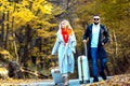 Autumn tourist couple with suitcase. Vacation and travelling concept.