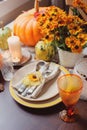 Autumn traditional seasonal table setting at home with pumpkins, candles and flowers Royalty Free Stock Photo