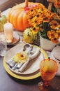 Autumn traditional seasonal table setting at home with pumpkins, candles and flowers Royalty Free Stock Photo