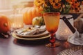 Autumn traditional seasonal table setting at home with pumpkins, candles and flowers Royalty Free Stock Photo