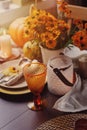 Autumn traditional seasonal table setting at home with pumpkins, candles and flowers Royalty Free Stock Photo