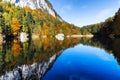 Autumn trees and blue sky reflected in mountain lake, Austria, Tyrol, Berglsteinersee Royalty Free Stock Photo