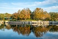 Autumn trees with blue sky reflection in water.