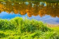 Autumn trees with golden leaves reflected in the clear water of the lake Royalty Free Stock Photo