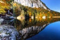 Autumn trees and mountain cliffs with blue sky reflected in a lake, Austria,Tyrol, Berglsteinersee Royalty Free Stock Photo