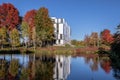 Autumn trees with red, green and yellow reflect in a park pond. Fall theme