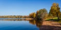 Autumn trees and sandy lake shore over blue sky Royalty Free Stock Photo