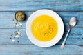 Autumn vegetable or pumpkin soup with seeds in white bowl on wooden turquoise table top view. Royalty Free Stock Photo