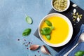 Autumn vegetable or pumpkin soup in white bowl on blue table top view. Royalty Free Stock Photo