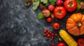 Autumn vegetables and fruits on a black stone background: Pumpkin, tomatoes, corn, pomegranate, persimmon, apple. Top view. Free