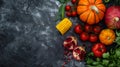 Autumn vegetables and fruits on a black stone background: Pumpkin, tomatoes, corn, pomegranate, persimmon, apple. Top view. Free