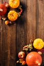 Autumn vertical background with pumpkins, acorns, berries, oak leaves on wooden table