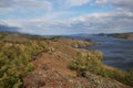 Autumn view of landscape of Lake Baikal with islands and peninsulas and mountains on horizon. Blue water, green trees,