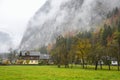 Autumn view with moutain, colorful trees and cottages in Hallstatt