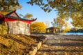 Autumn view of riverside park with wooden houses and benches Royalty Free Stock Photo