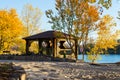 Autumn view of riverside park with wooden houses and benches Royalty Free Stock Photo