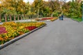 Autumn view of Taras Shevchenko City Garden in Kharkiv Ukraine. People walk along the alleys among flowering flower beds against