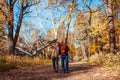 Autumn walk. Senior couple walking in fall forest. Happy man and woman talking and relaxing outdoors Royalty Free Stock Photo