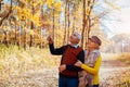 Autumn walk. Senior couple walking in fall park. Happy man and woman talking and relaxing outdoors Royalty Free Stock Photo