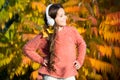 Autumn walks with nice songs. Listening audio best way help child improve vocabulary. Kid girl relaxing near autumn tree