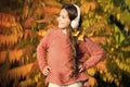 Autumn walks with nice songs. Listening audio best way help child improve vocabulary. Kid girl relaxing near autumn tree