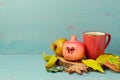 Autumn wallpaper with red tea cup, pomegranate and fall leaves