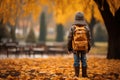 Autumn wanderlust Little boy with backpack strolls through park Royalty Free Stock Photo