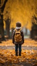 Autumn wanderlust Little boy with backpack strolls through park Royalty Free Stock Photo