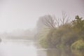Autumn weather. Overcast rainy dawn. Haze and mist over water. Fog over river Royalty Free Stock Photo
