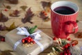 Autumn or winter composition. A Cup of tea, a gift, autumn leaves, on a wooden background. The view from the top. Royalty Free Stock Photo