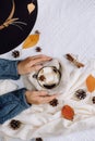 Women`s hands hold a cup with hot coffee with marshmallows, scarf, cookies, bumps and autumn leaves. Royalty Free Stock Photo