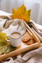 Autumn and winter home still life: a cup of coffee, cookies and yellow leaves. Seasonal breakfast, morning coffee.