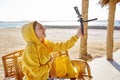 Autumn winter season in tropical seaside resort. Middle-aged woman recording video on smartphone Royalty Free Stock Photo