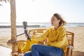 Autumn winter season in tropical seaside resort. Middle-aged woman recording video on smartphone Royalty Free Stock Photo