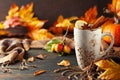 Autumn or winter spice tea in mug with seasonal fruits, berries, pumpkin and leaves on wooden table Royalty Free Stock Photo