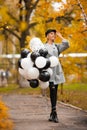 Autumn woman in autumn park with balloons. Fashion girl in gray coat